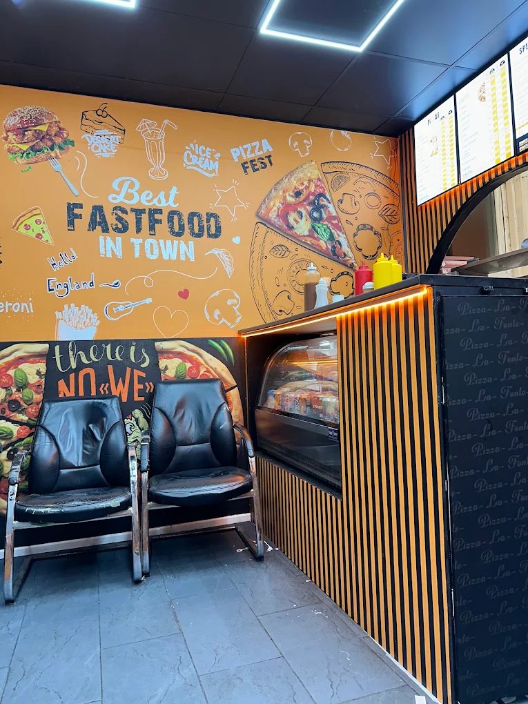 Inside Pizza La Fonte with orange walls and seating area